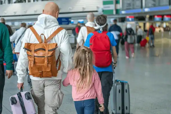 Famille avec valises à l'aéroport, choix d'assurance voyage Europe selon profil