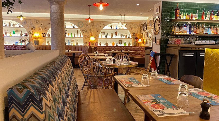 Devanture de restaurant avec menu plastifié en plusieurs langues, signal d'un piège à touristes