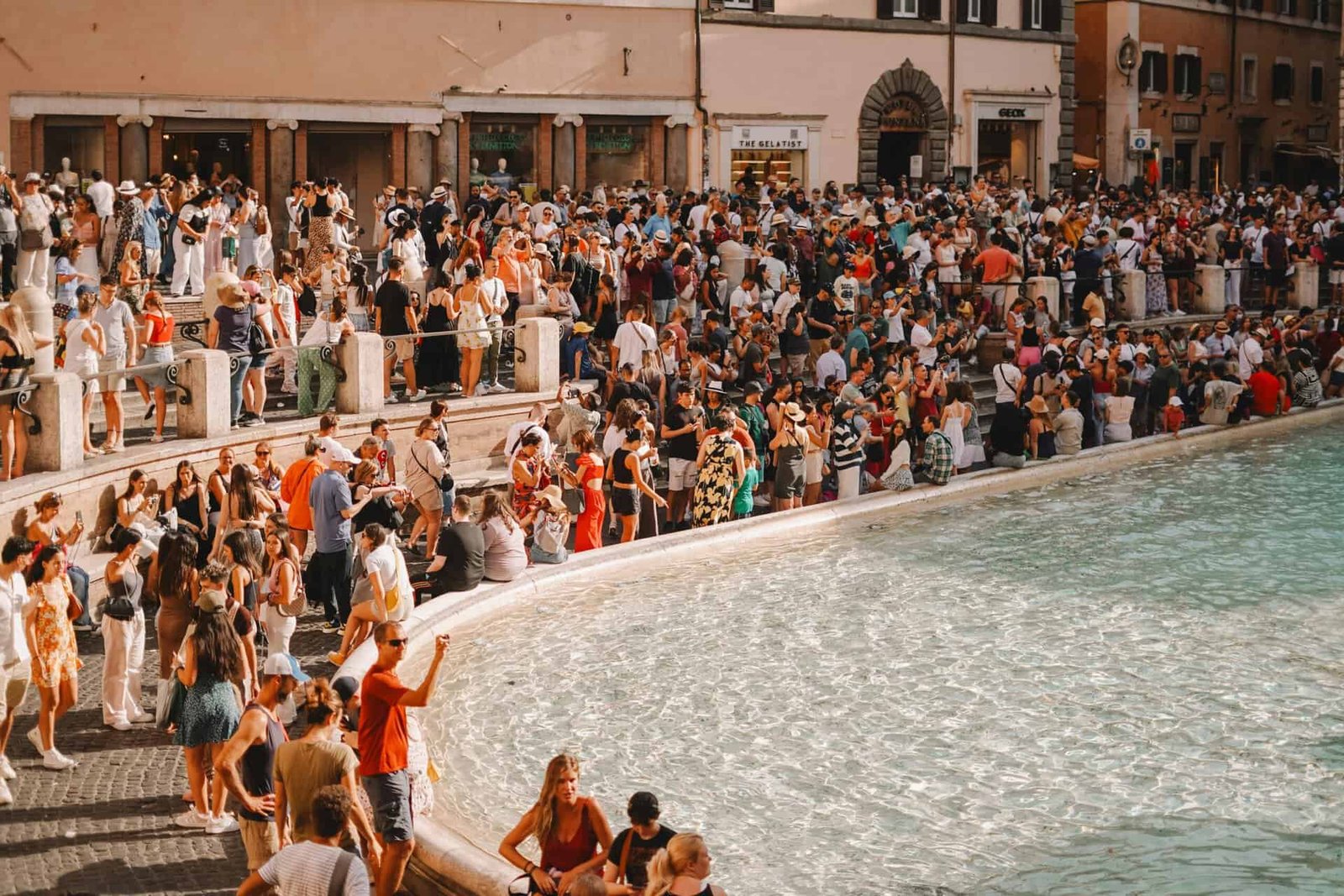 Foule devant la fontaine de Trevi à Rome, zone à risque d'arnaques touristiques en 2026