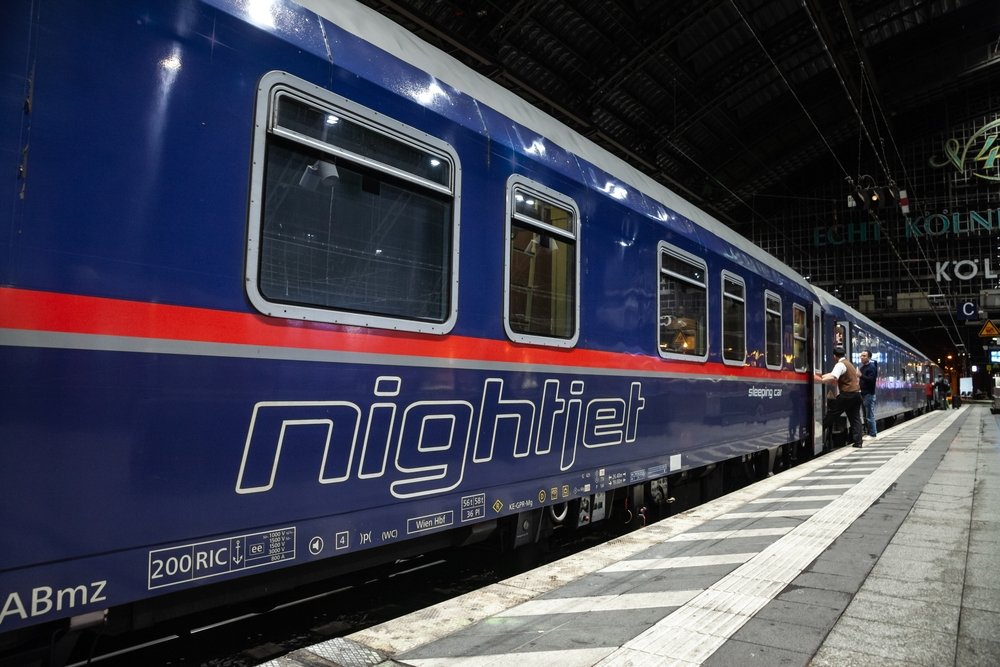 Train de nuit Nightjet à quai dans une gare européenne illuminée la nuit